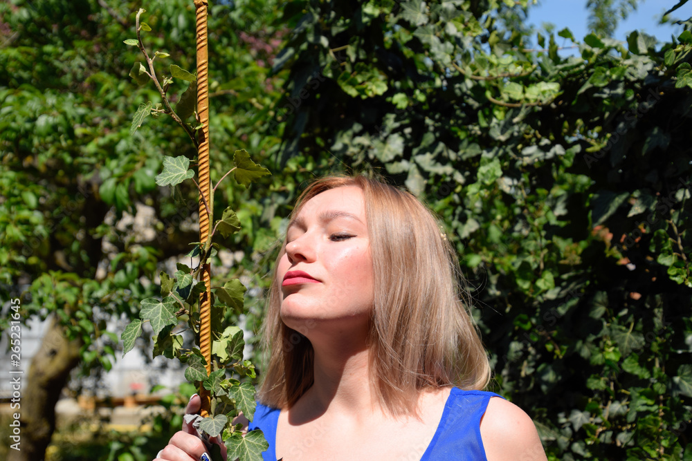 Portrait of a girl in a blue dress on a background of green arbor of ivy. Portrait of a girl in a blue dress on a background of green arbor of ivy.