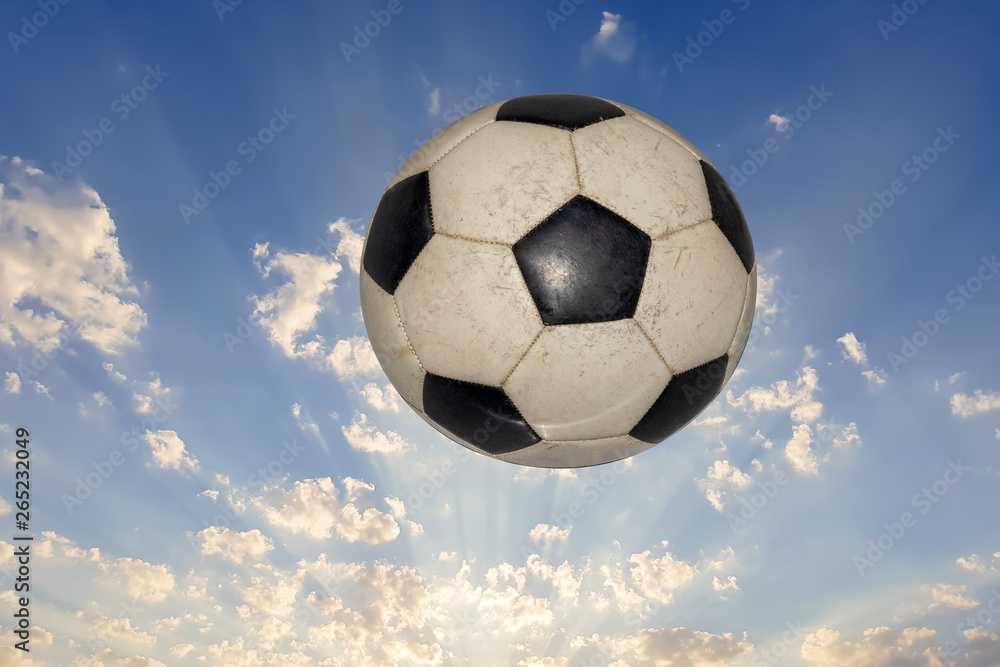 soccer ball flies in the sky with clouds