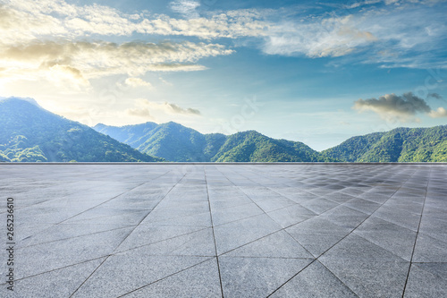 Empty square floor and green mountain natural landscape at sunset