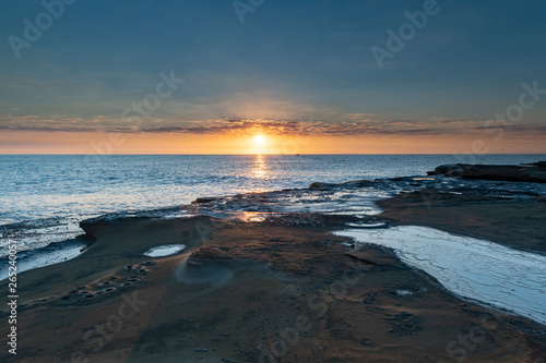Rock Platform Sunrise Seascape with Light Smattering of Clouds
