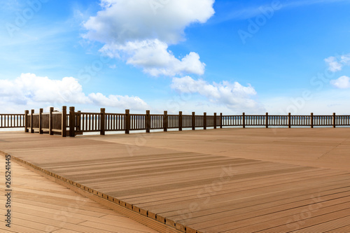 Lakeside wood floor platform and blue sky with white clouds