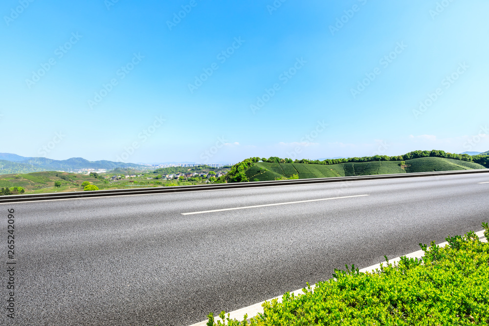 Fototapeta premium Country road and green mountains natural landscape under the blue sky