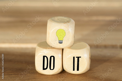 Holzwürfel mit einer Glühbirne und dem Slogan Do It