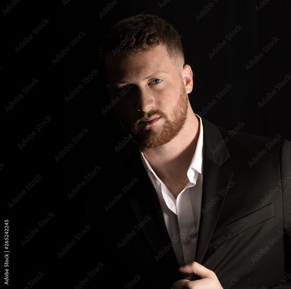 handsome man wearing a suit is looking at you in low key portrait handsome man wearing a suit is looking at you in low key portrait