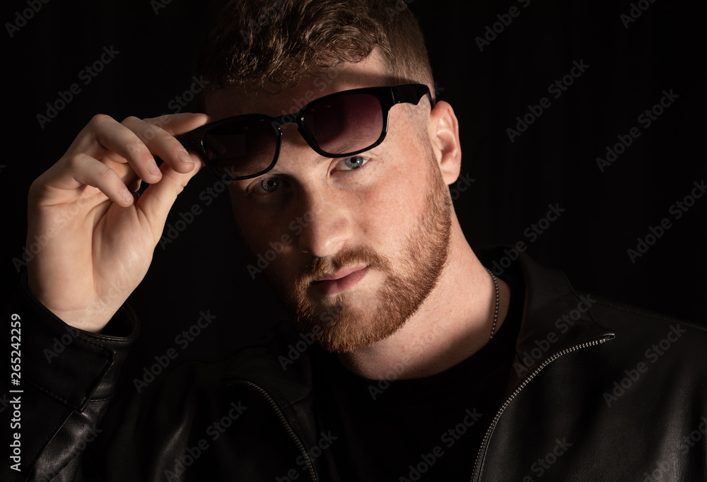 man with sunglasses shows his blue eyes