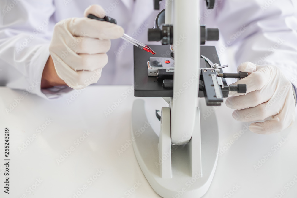 A scientist hands working in laboratory with test tube microscope and solutions. A scientist hands working in laboratory with test tube microscope and solutions.