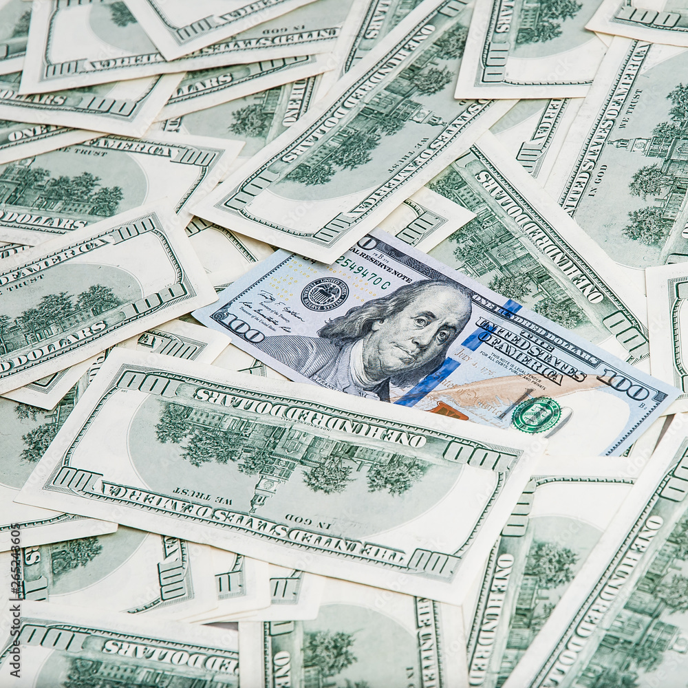 Background from dollars. Notes of one hundred American dollars are scattered across the background. Background from dollars. Notes of one hundred American dollars are scattered across the background.