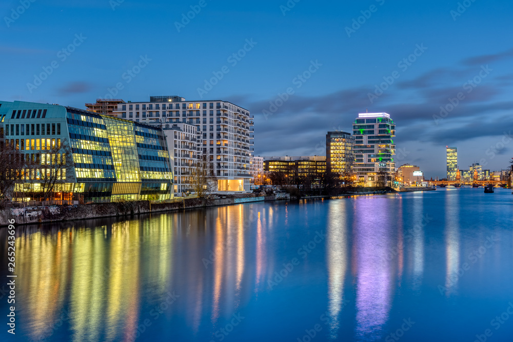 The river Spree in Berlin at night with modern buildings at the river banks