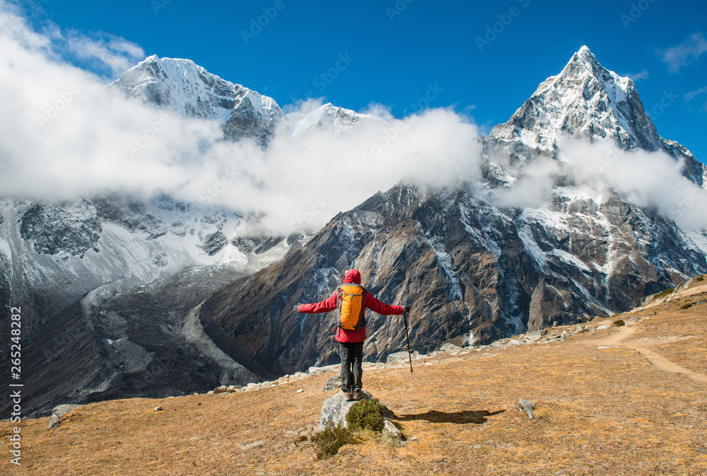 Trekker standing in front of Mt.Taboche (6,501 m) at the left side and Mt.Cholatse (6,440 m) at the right side during trekking from Lobuche to Dzongla village in Nepal.
