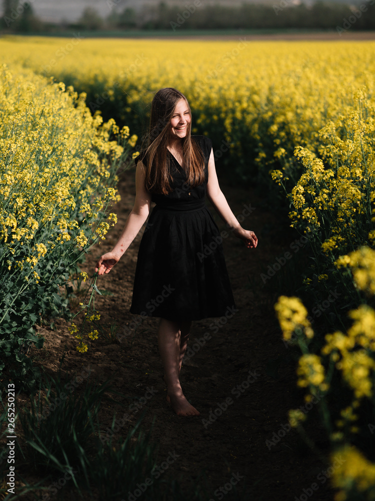 Fototapeta premium Happy smiling girl at rapessed field