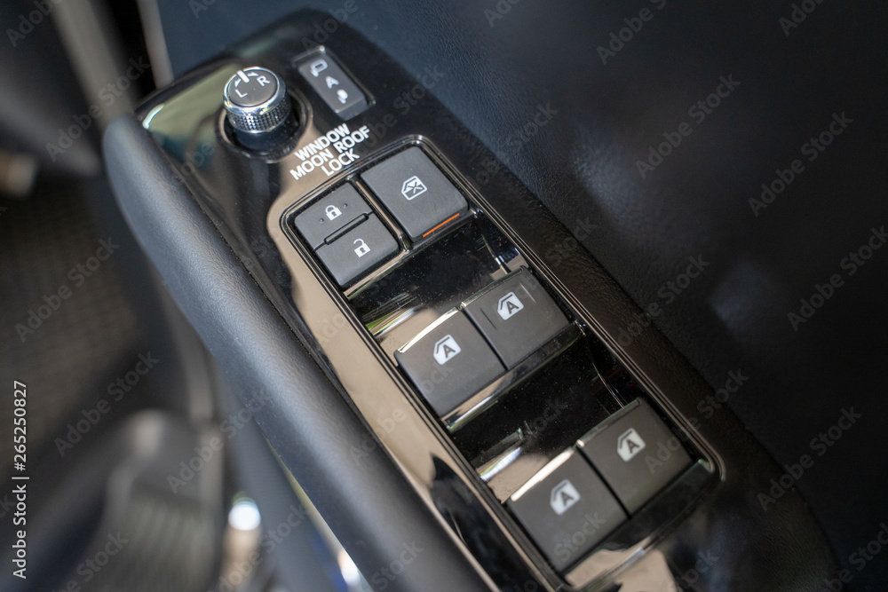  Auto window button control inside driver place.Mirror control knob in a luxury car.