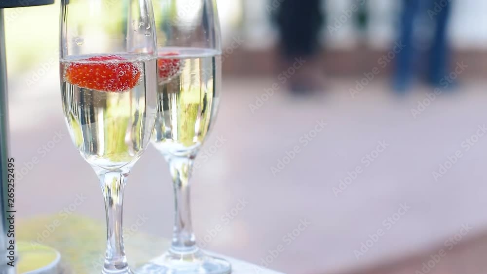 Strawberry in champagne glass and walking away couple Strawberry in champagne glass and walking away couple