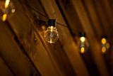 Hanging light bulbs on a wooden wall. Background wooden boards with lamps
