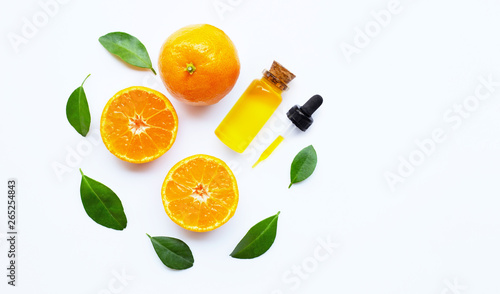 Essential oil with oranges on white.