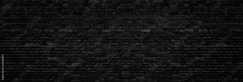 Wide old black shabby brick wall texture. Dark masonry panorama. Brickwork panoramic grunge background