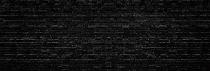 Wide old black shabby brick wall texture. Dark masonry panorama. Brickwork panoramic grunge background