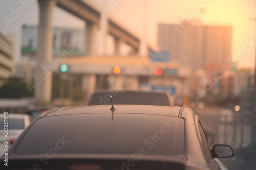 Sun flare in morning on roof of car on city view background