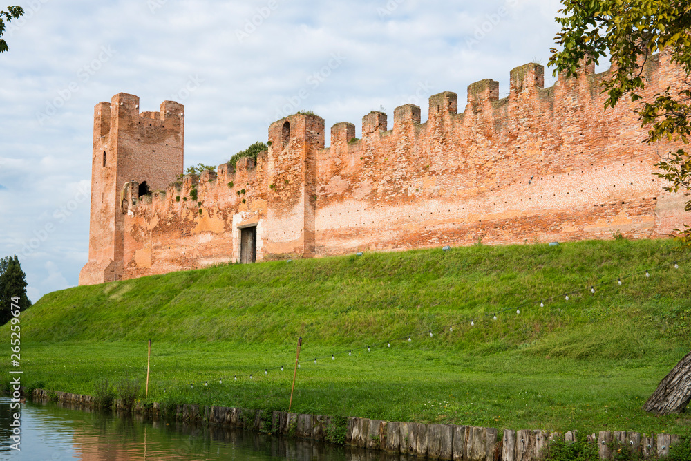 city wall with  battlements and tower on green hill in Castelfranco Veneto, Italy