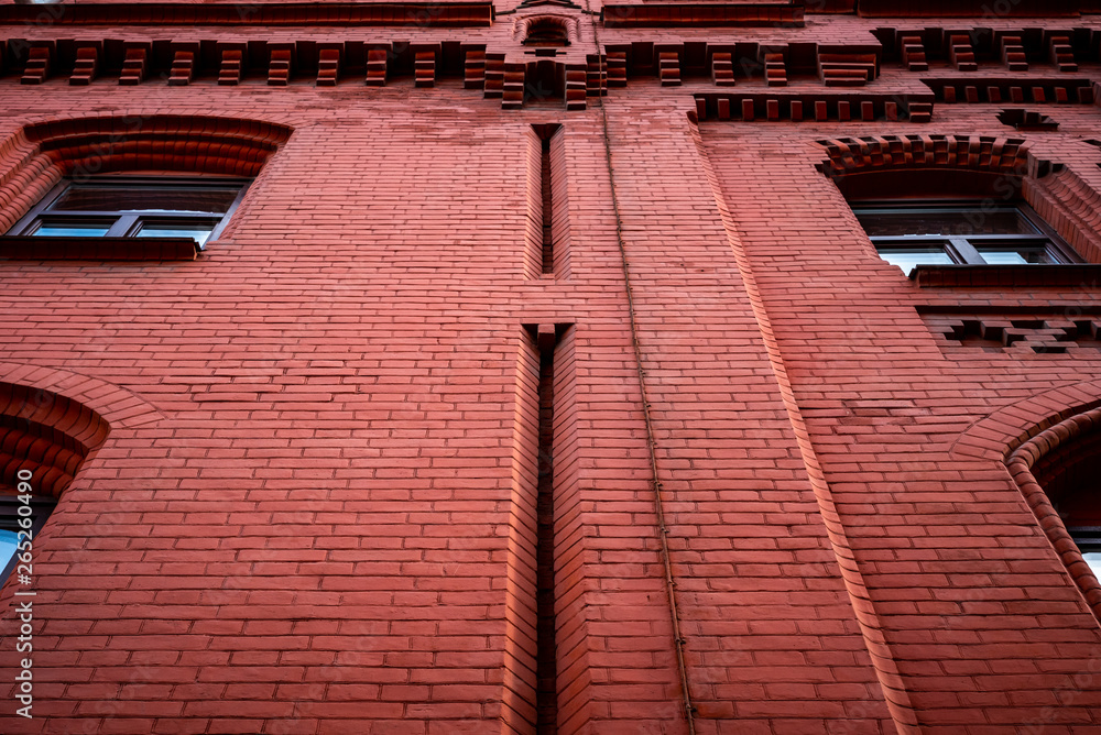 Fototapeta premium Red brick wall with windows. Bottom view.