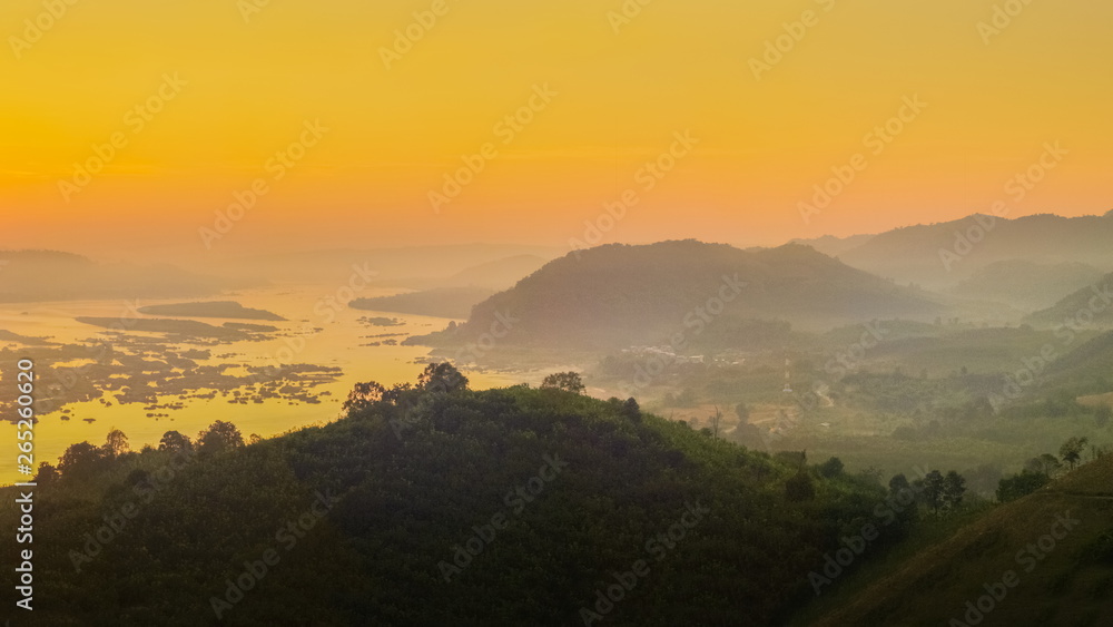 sunrise at Phu Huay E San View Point, view of the hill around with sea of mist above Mekong river with red sun light in the sky background, Ban Muang, Sang Khom District, Nong Khai, Thailand.