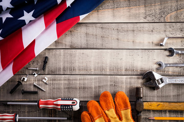 Labor Day, USA America flag with many handy tools on wooden background texture.
