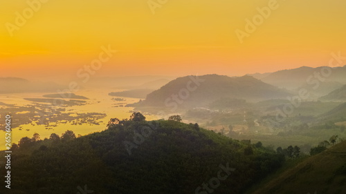 sunrise at Phu Huay E San View Point, view of the hill around with sea of mist above Mekong river with red sun light in the sky background, Ban Muang, Sang Khom District, Nong Khai, Thailand.