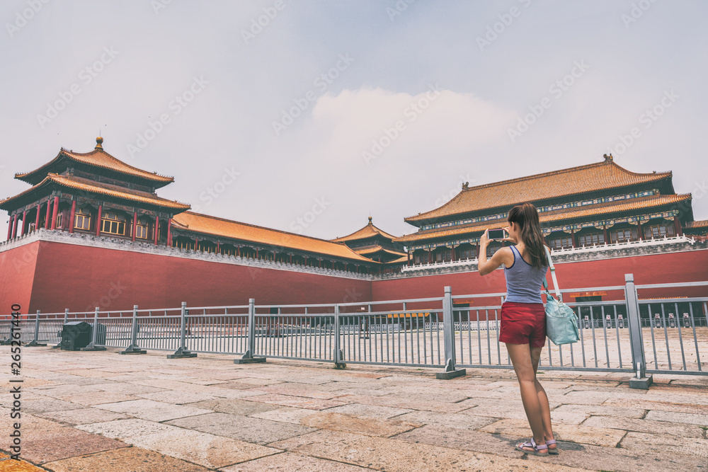 Fototapeta premium China travel lifestyle. Asian woman taking smartphone picture of Beijing tourist attraction, ancient dynasty building.