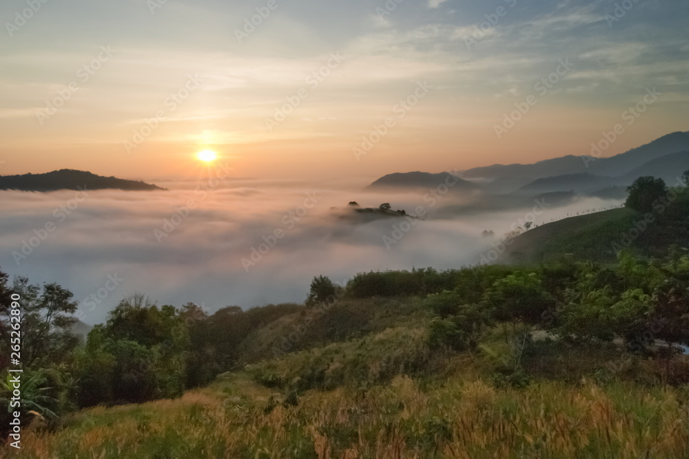 sunrise at Phu Huay Isan View Point, view of the hill around with sea of mist above Mekong river with blue sky background, Ban Muang, Sang Khom District, Nong Khai, Thailand.