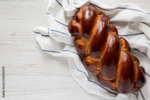 Fotografie Homemade jewish challah bread on a white wooden background, top view