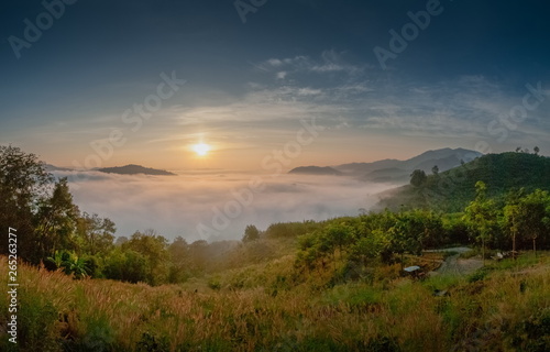 sunrise at Phu Huay Esan View Point, view of the hill around with sea of mist above Mekong river with blue sky background, Ban Muang, Sang Khom District, Nong Khai, Thailand.