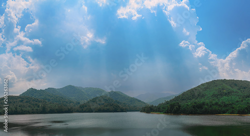Reservoir with surrounding mountains and beautiful skies in Thailand.