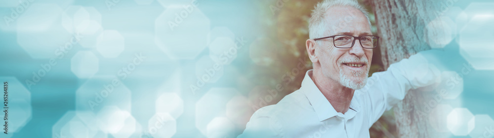 Portrait of a mature man with an arm against a tree, light effect. panoramic banner Portrait of a mature man with an arm against a tree, light effect. panoramic banner