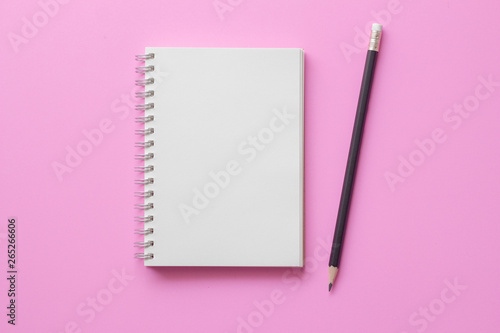 Blank note book with pencil on pink background.minimal style.