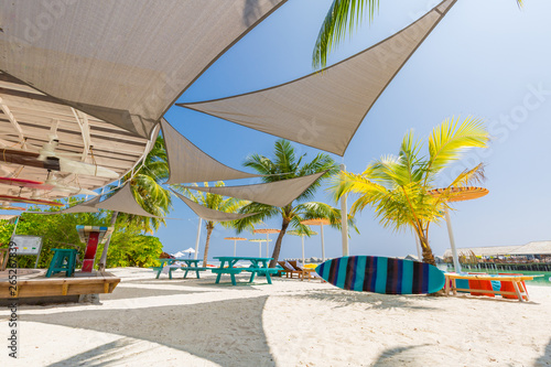 Fototapeta Naklejka Na Ścianę i Meble -  Outside lounging relax vacation beach bar blue paradise sea and coconut tree in travel easy slow chill refreshment summer location using for copy space background