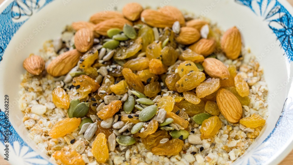Breakfast: oatmeal with raisins, pumpkin and sunflower seeds and almonds. Top view Breakfast: oatmeal with raisins, pumpkin and sunflower seeds and almonds. Top view