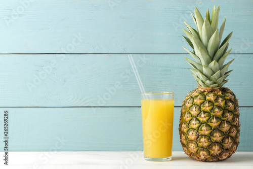 Ripe pineapple fruit and pineapple juice on a blue wooden background. place for text.