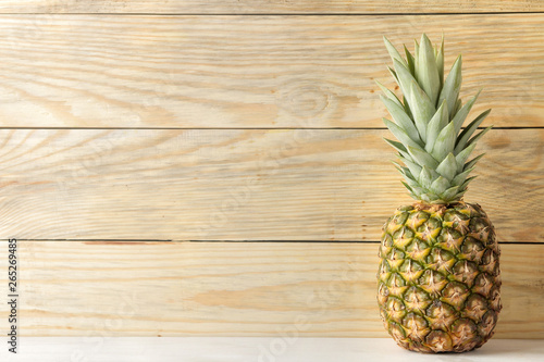 Ripe pineapple fruit on natural wooden background. summer. space for text