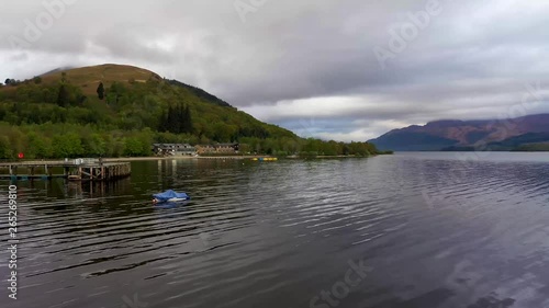 Aerial depiction of the beautiful village of Luss on the banks of Loch Lomond, featuring The Lodge on the Lake and Ben Lomond in the background.
