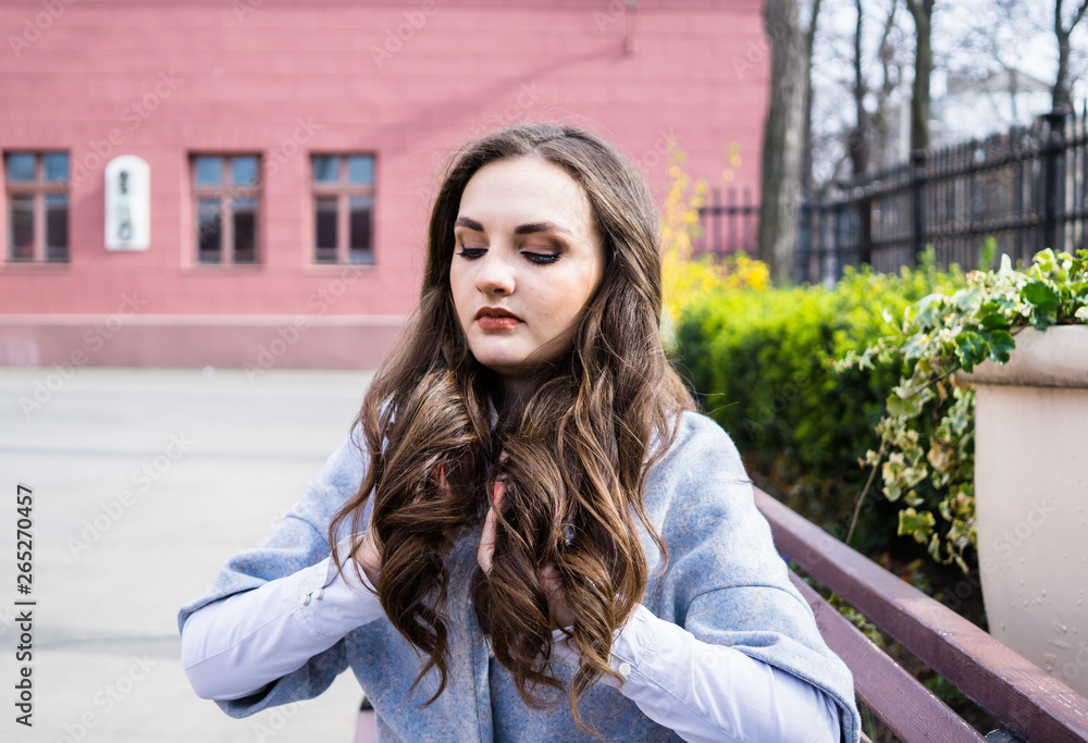 Fototapeta premium Beautiful smiling young lady in blue suit with long hair