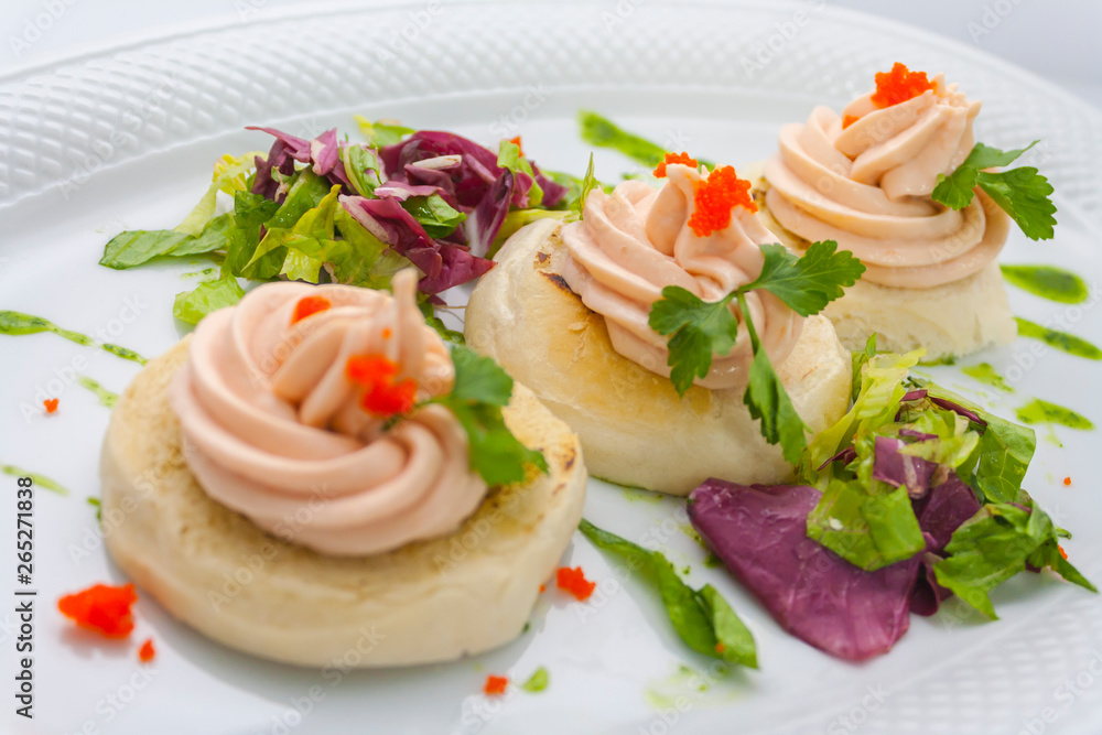 tartlets with red caviar, butter, sprigs of parsley and lettuce on a white plate on a white background tartlets with red caviar, butter, sprigs of parsley and lettuce on a white plate on a white background