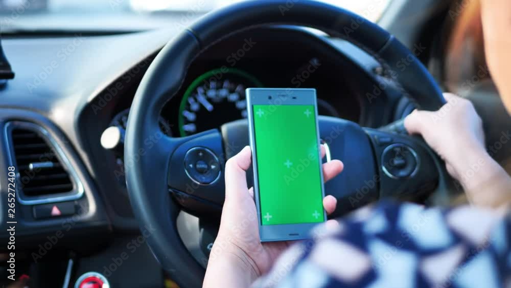 woman driving on the roads and the use of green-screen smart phone. See a map or listen to music. woman driving on the roads and the use of green-screen smart phone. See a map or listen to music.