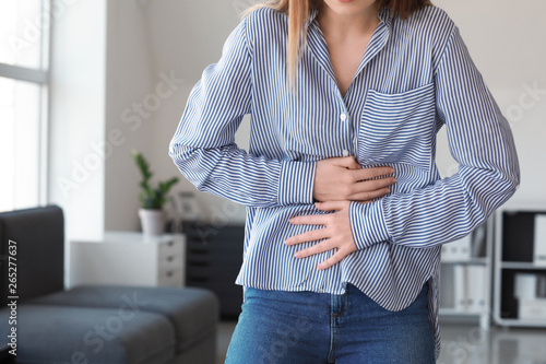 Woman suffering from stomachache at home photo