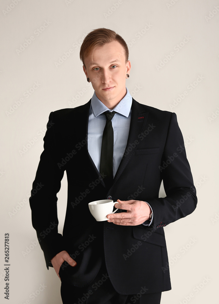 Handsome stylish businessman with cup of coffee in office Handsome stylish businessman with cup of coffee in office