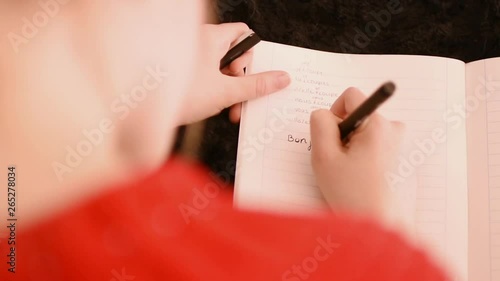 Girl doing homework on the couch, top view
