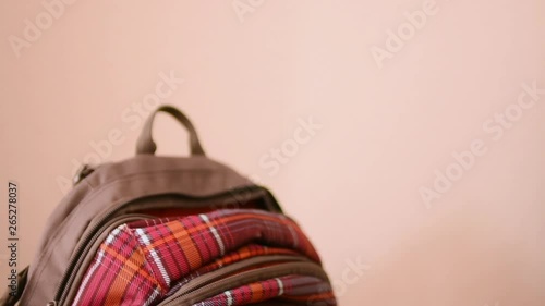 The girl pulls out a notebook for homework from a backpack