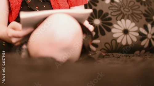 Girl doing homework on the sofa, side view
