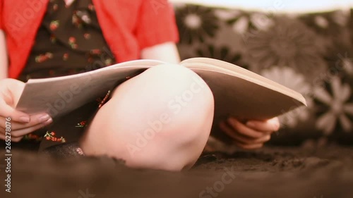Girl doing homework on the sofa, side view