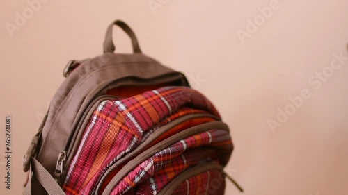 The girl pulls out a notebook for homework from a backpack