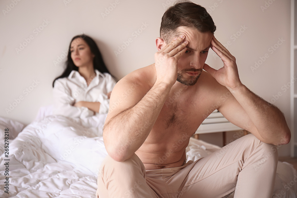 Young sad man sitting on bed after quarrel with wife Young sad man sitting on bed after quarrel with wife