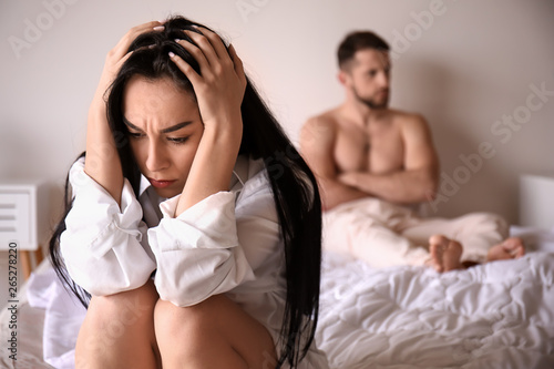 Fotografie Young sad woman sitting on bed after quarrel with husband